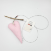 Die „Fotoleine mit Herz“ zeigt ein rosa gepunktetes Herzornament aus Treibholz und Draht, das neben einem Paket mit der Aufschrift „Happy Fun“ ruht.