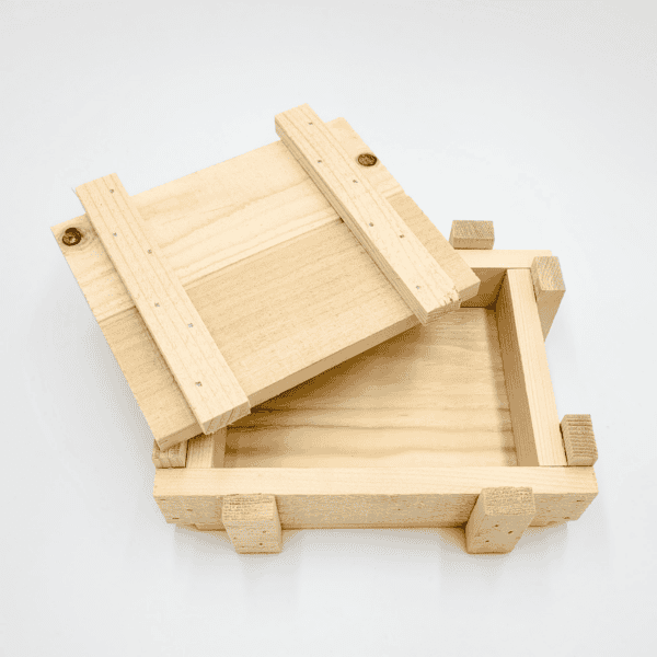 Die Holzkiste, eine Holzbox mit geöffnetem Schiebedeckel, gibt den Blick auf das Innere vor weißem Hintergrund frei.