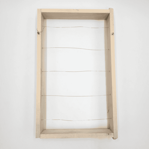 Der Honigrahmen besteht aus einem Holzrahmen mit fünf parallelen dünnen Drähten in der Mitte.