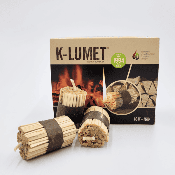 Drei K-LUMET Feueranzünder werden vor ihrer Verpackung präsentiert, verziert mit Bildern von Brennholz und Flammen.